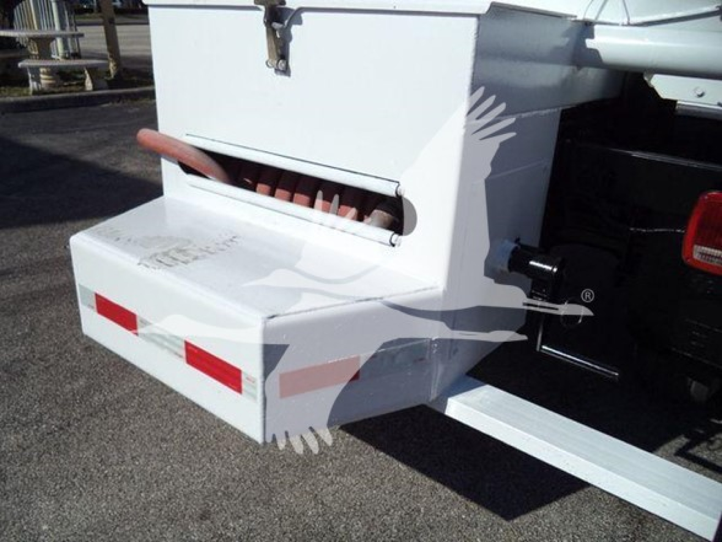 Rear view of a white Hino 338 truck bed bumper with red reflectors and a storage box mounted at the back.