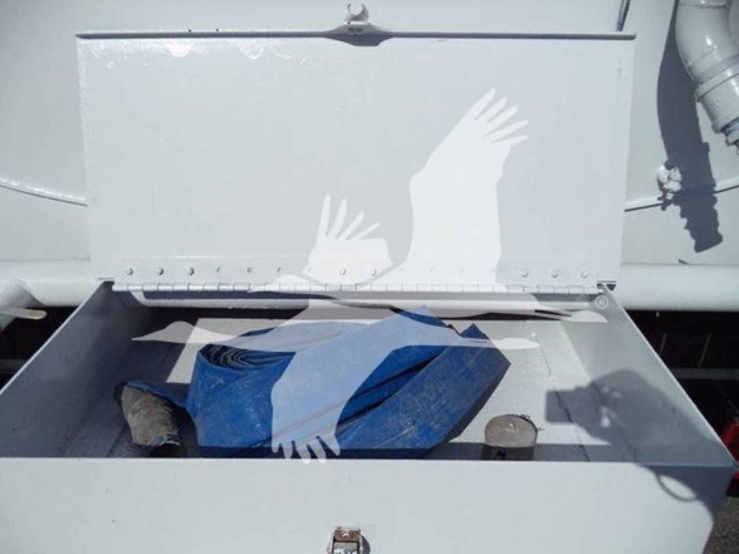 Hino 338 service compartment showing storage drawer with blue strap and metal components.