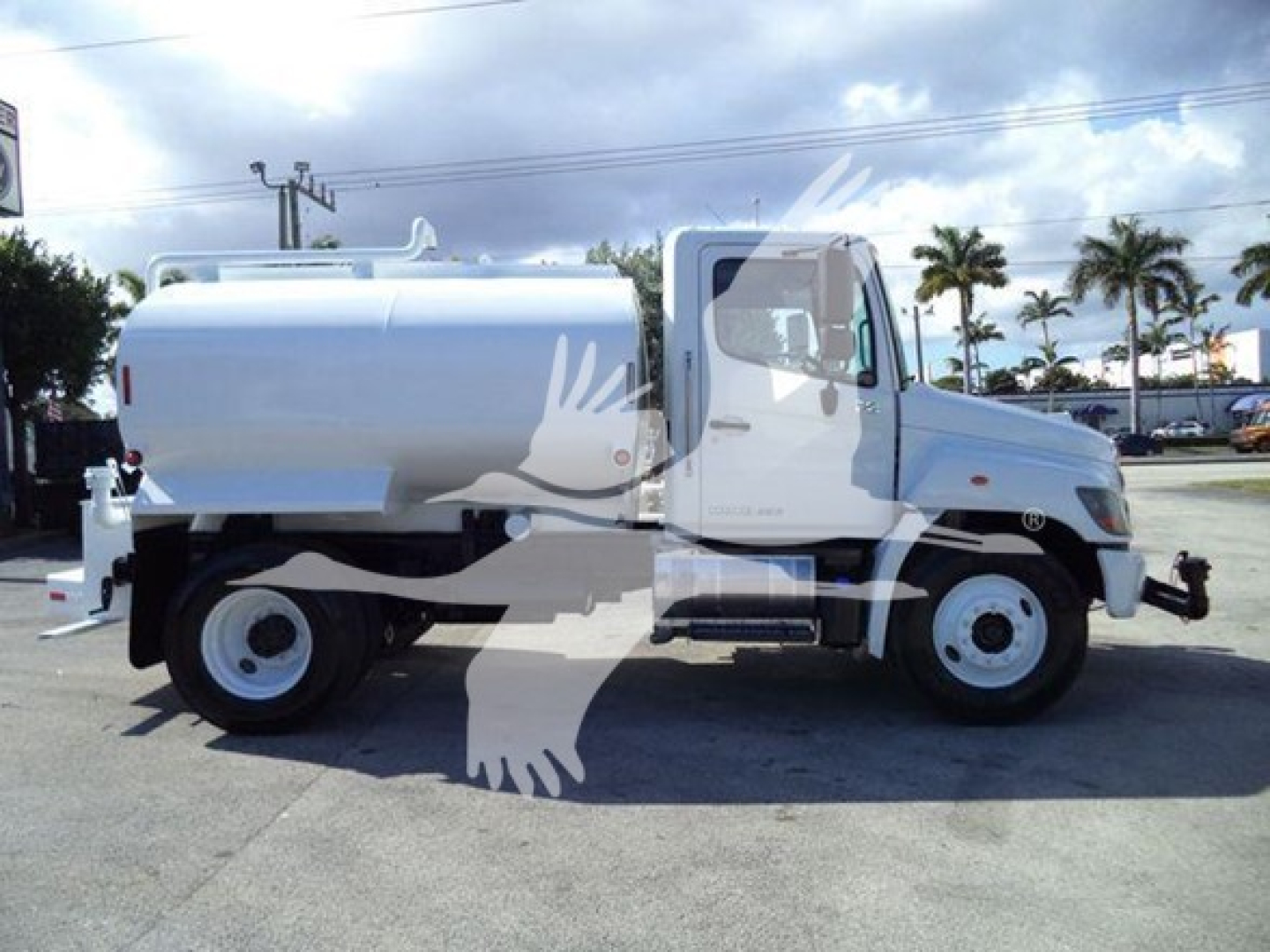 Hino 338 commercial truck with silver tanker body, side view showing cab and tank.
