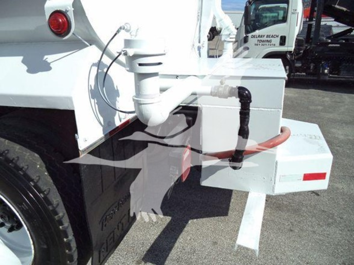Hino 338 truck rear showing hitch assembly and utility box with hoses and piping, side view.