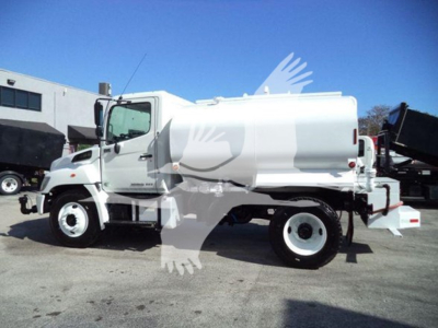 2019 Hino 338 dump truck in side view showing cab, white body, and rear hopper with dual rear wheels.