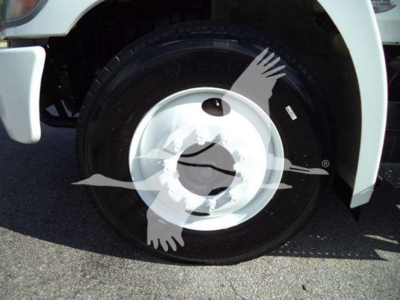 Front wheel and tire of a 2019 Hino 338 truck showing white steel wheel and black tire. Partial fender and wheel well visible.