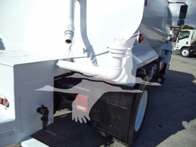 Truck rear view showing large white tanker and black dual rear tires with red mud flap.