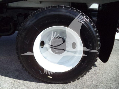 Wheel of a 2019 Hino 338 truck showing a black tire with white steel rim and reflection; no legible label text visible in image.