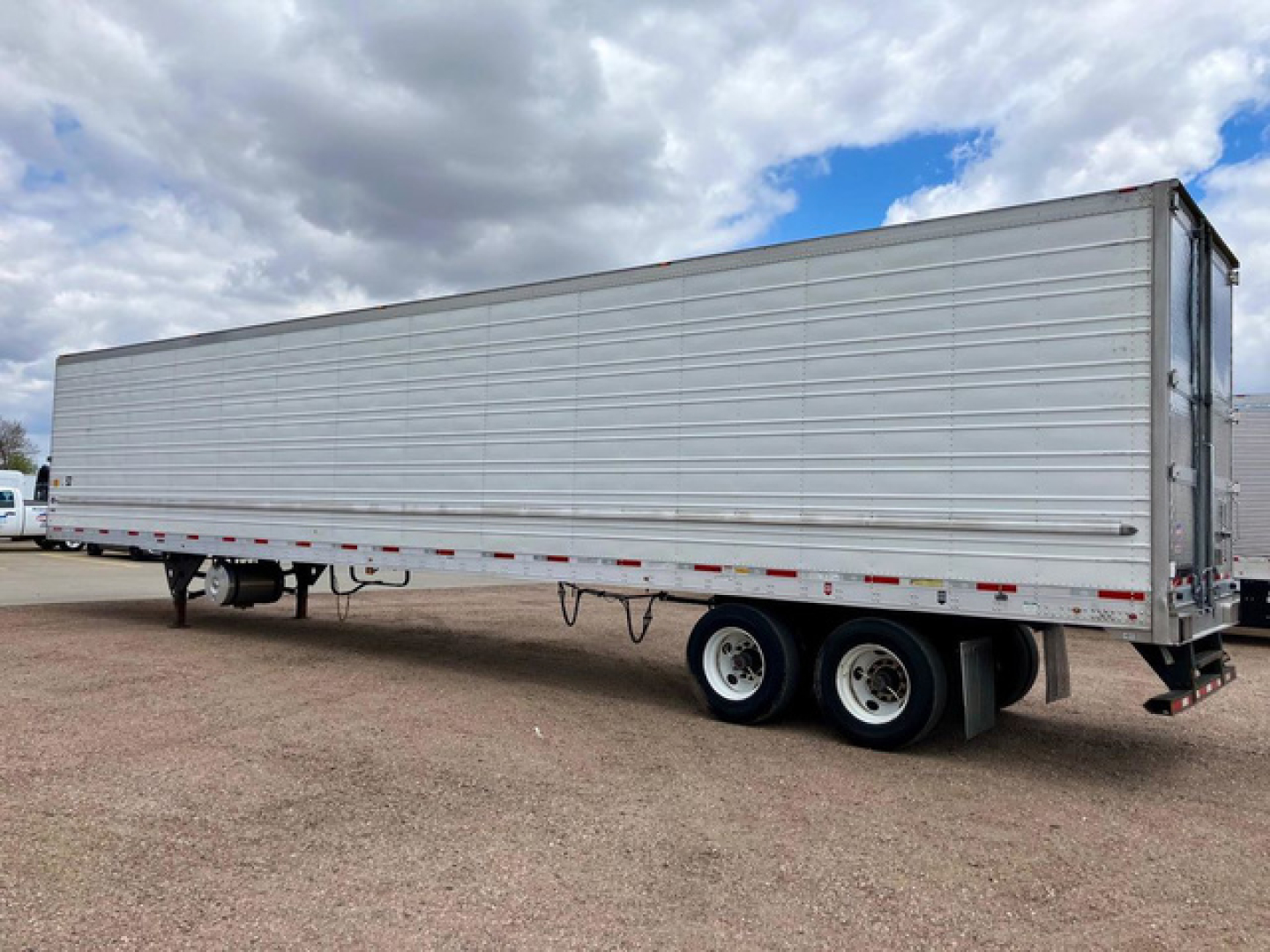 Utility reefer trailer showing side profile with aluminum panels and dual rear axles.