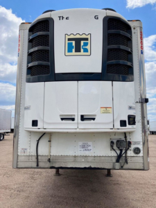 Trailer refrigeration unit back view showing cold air condenser, vertical cooling vents, and TS logo on unit doors.