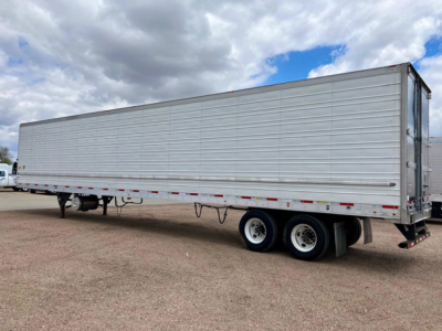 Utility reefer trailer showing side profile with aluminum panels and dual rear axles.