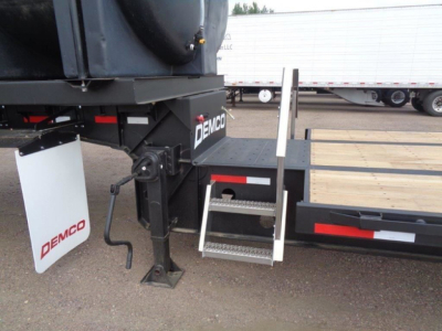 Demco Liquid Tender trailer hitch area showing side step, ladder, and Demco branding.