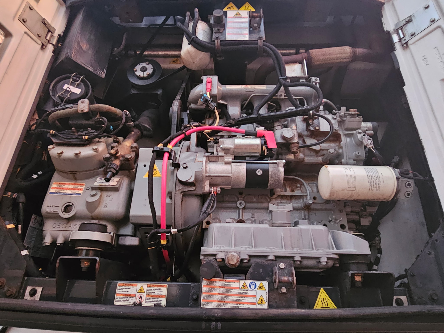 Technical engine bay of Hyundai ThermoTech TL trailer showing diesel engine with hoses, wiring, and reservoir caps.