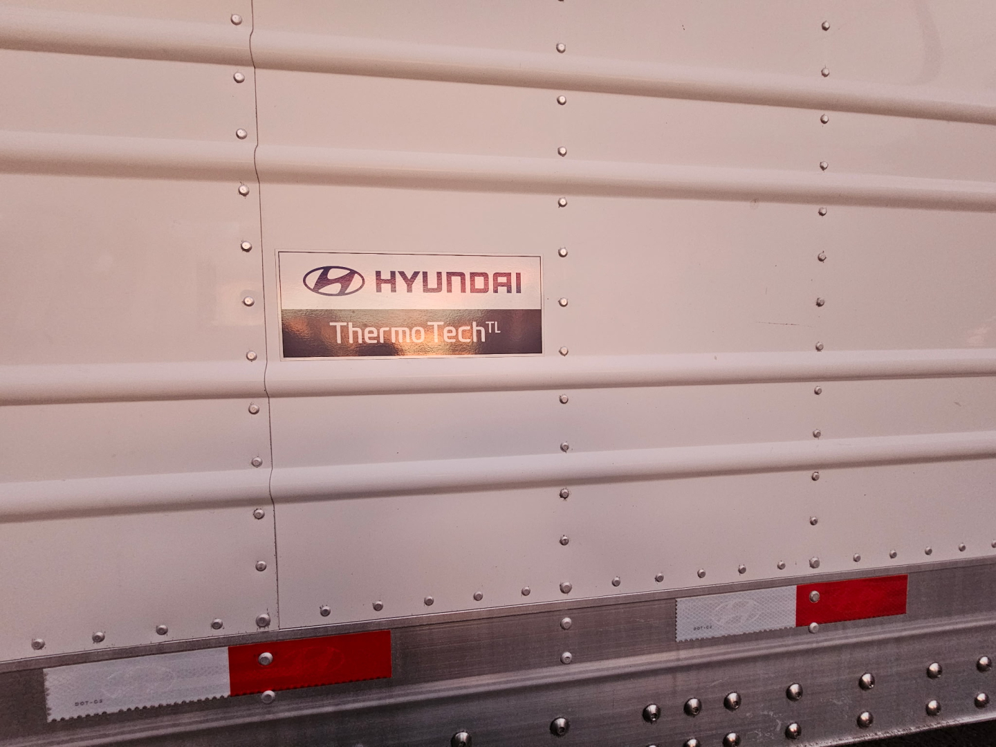 Hyundai ThermoTech TL badge on side of trailer with riveted metal panels and red/white reflective trim.