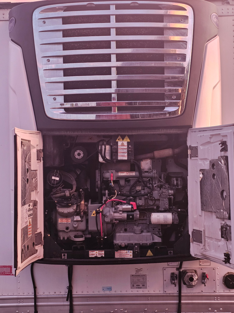 Reefer trailer engine bay with open rear doors showing engine and components.