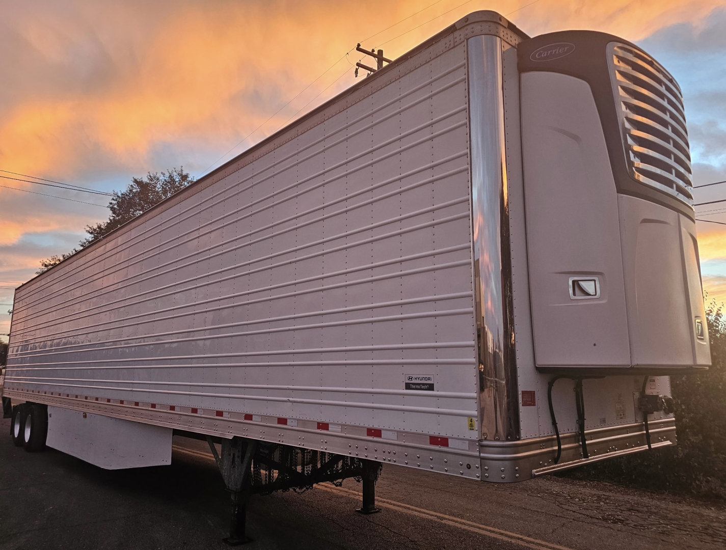 Trailer side view showing a ThermoTech TL refrigerated trailer with a front refrigeration unit. Side panels and support legs visible.