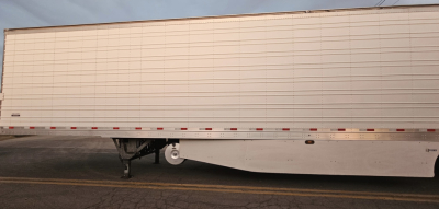 Trailer sideshow twin-axle reefer trailer with undercarriage and landing gear visible.