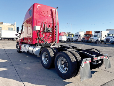 Freightliner Cascadia 126 semi tractor rear view showing red cab, dual rear axles, and fifth wheel with mud flaps.