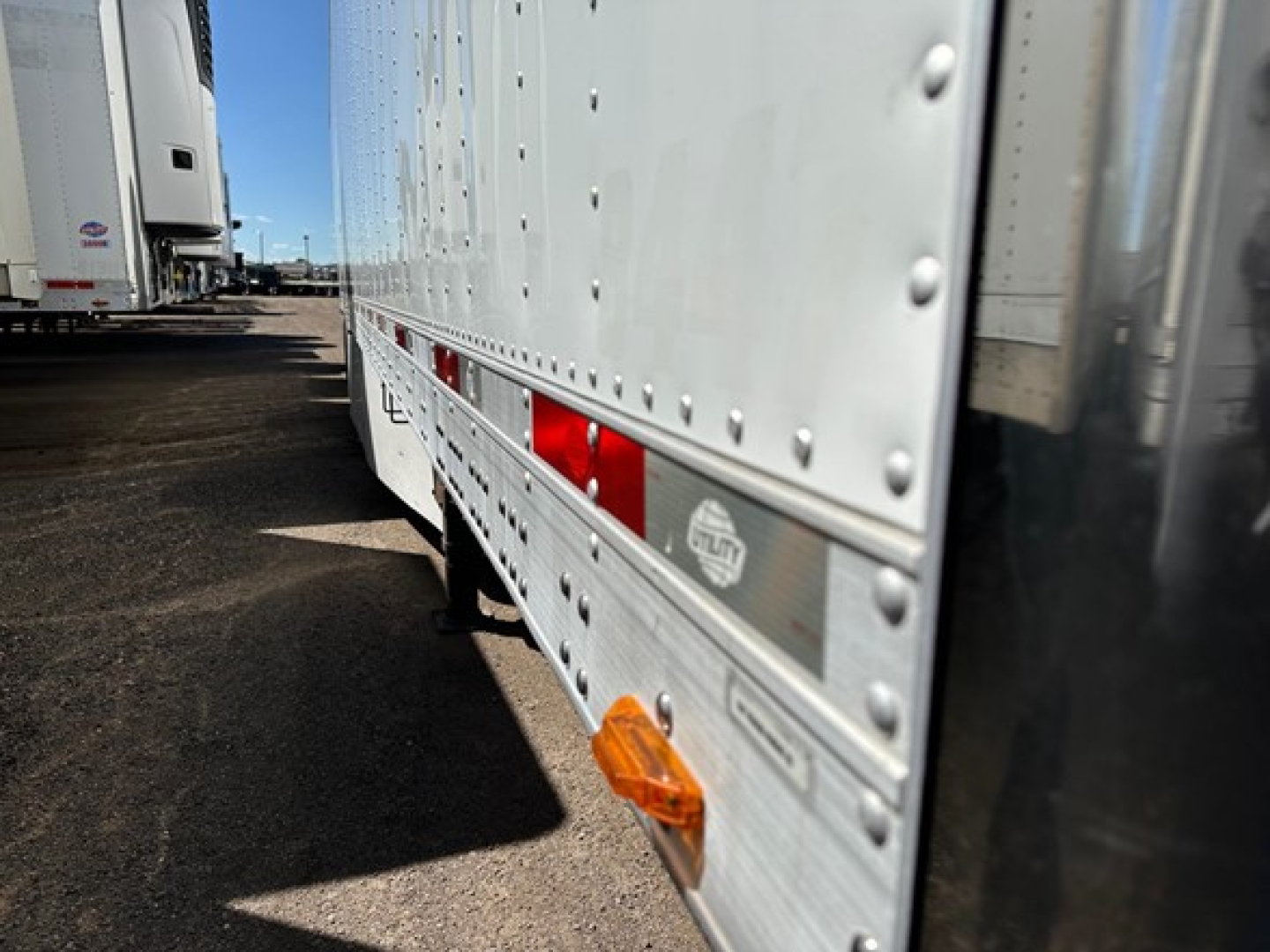 Trailer side view with riveted aluminum wall panels and clearance lights on a 2017 Utility 3000R trailer.