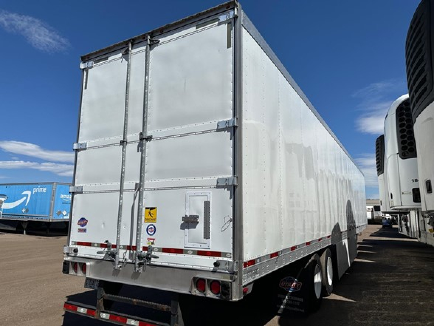 Rear view of a white Utility 3000R trailer showing doors, bumper, and rear lights.
