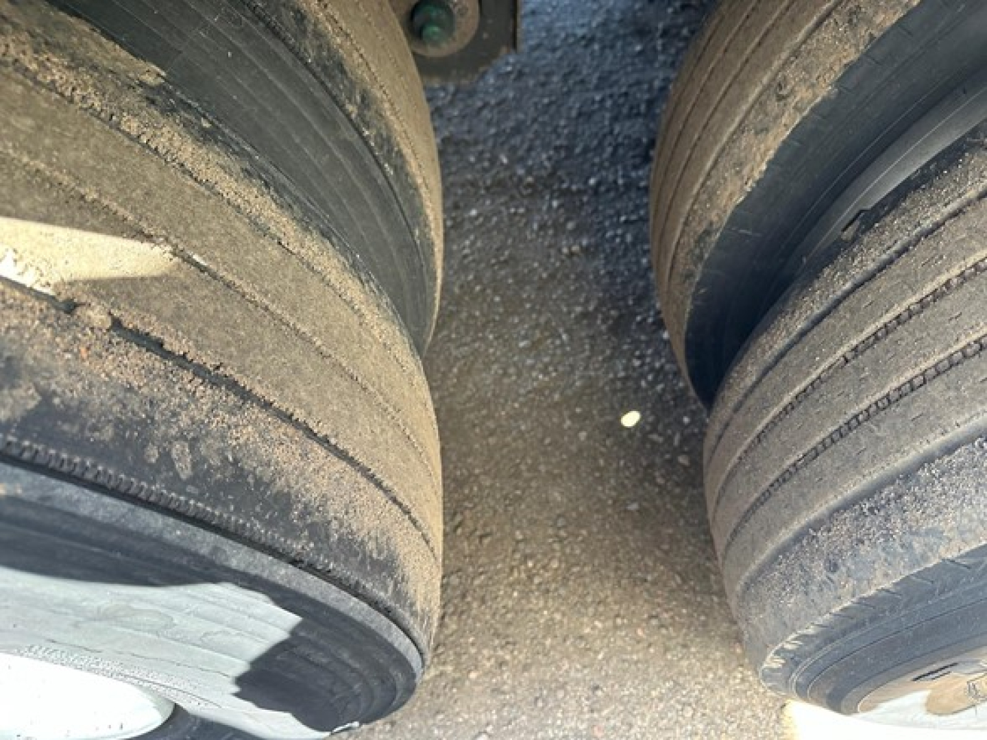 Dual truck trailer tires with wear marks and dirt on the treads, visible on a Utility 3000R trailer wheel area.