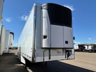 Rear view of a white 2017 Utility 3000R refrigerated trailer with a black refrigeration unit at the front, wiring and panels visible, other trailers in background.