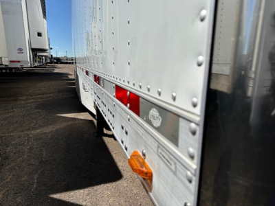 Trailer side view with riveted aluminum wall panels and clearance lights on a 2017 Utility 3000R trailer.