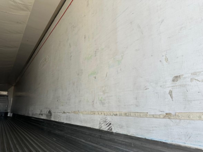 Trailer interior sidewall and loading floor showing weathered aluminum wall with a horizontal strip, in a Utility 3000R reefer trailer.