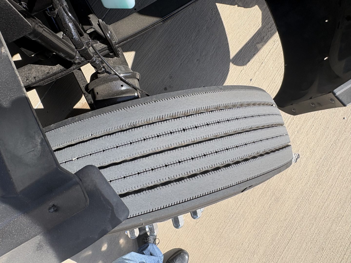 Peterbilt 579 truck image showing a close-up of the front passenger side dual-step step area with tire tread and suspension components visible.