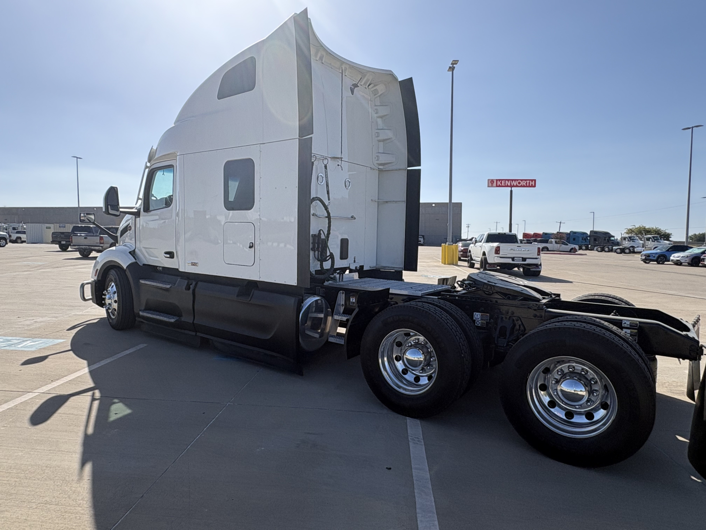 Peterbilt 579 tractor in a parking lot, side view showing sleeper cab and rear dual wheels.