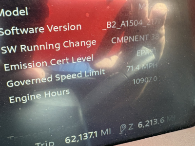 Peterbilt 579 dashboard display showing software version, emission cert level, governed speed limit 71.4 MPH, engine hours 10907, trip 62,137.1 mi, total 6,213.6 mi.
