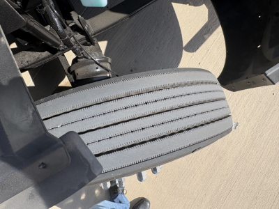 Peterbilt 579 truck image showing a close-up of the front passenger side dual-step step area with tire tread and suspension components visible.