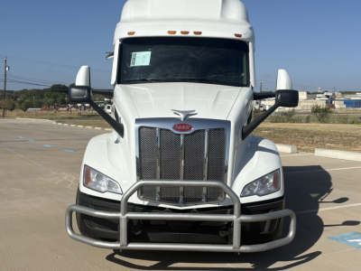 Peterbilt 579 truck front view showing grille guard and white cab.