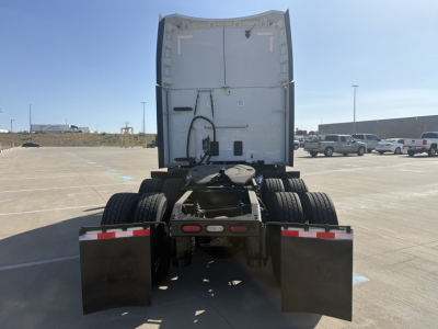 Peterbilt 579 rear view showing tractor and dual rear axles with mudflaps and chassis details, skyline of parking lot. Visible text: VIN 1XPBDP9X4RD602328 on listing context not on image.