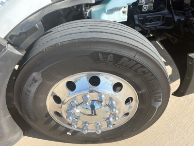 Wheel/tire of a Peterbilt 579 truck showing Michelin tire and chrome hubcap.