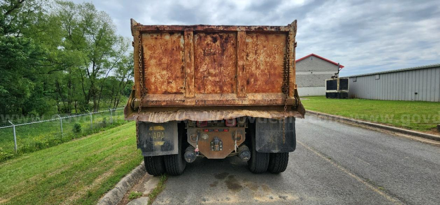Dump truck bed of a 2002 International DT530 rear view showing rusted dump bed and dual rear tires.