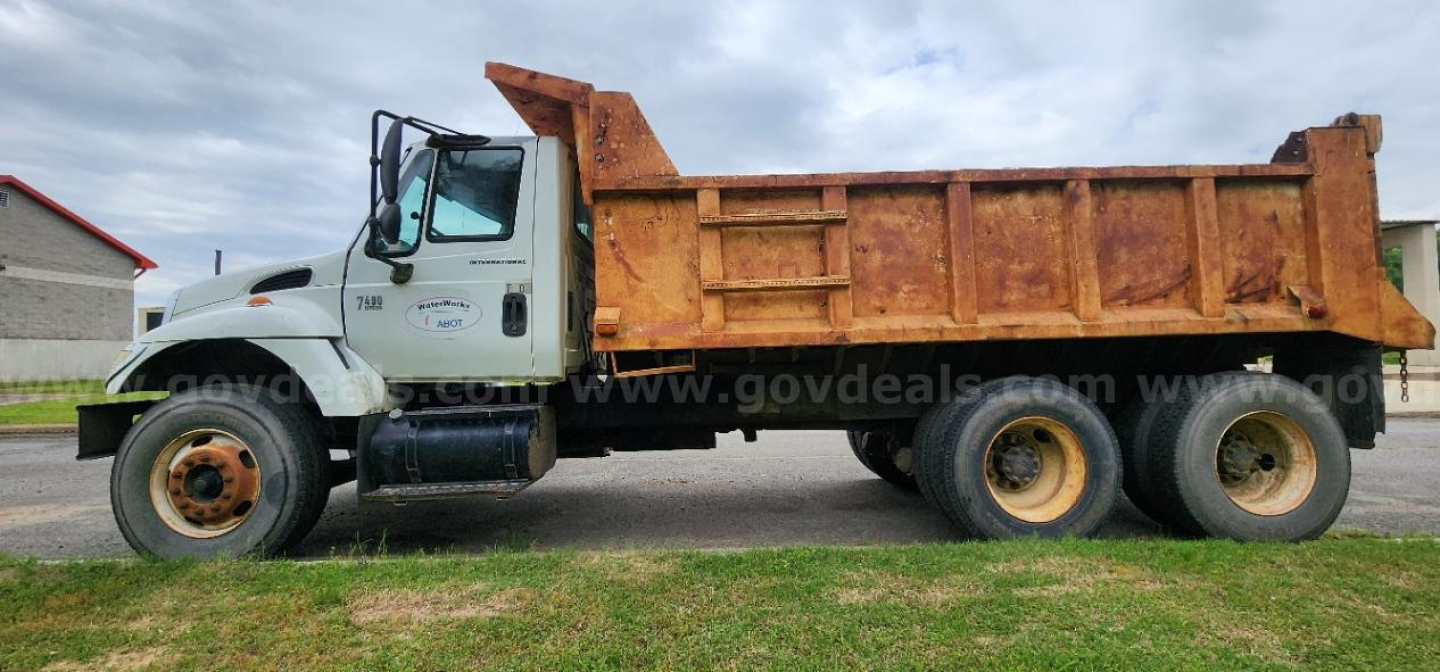 Dump truck showing International DT530 engine bay and dump bed with dual rear axles.