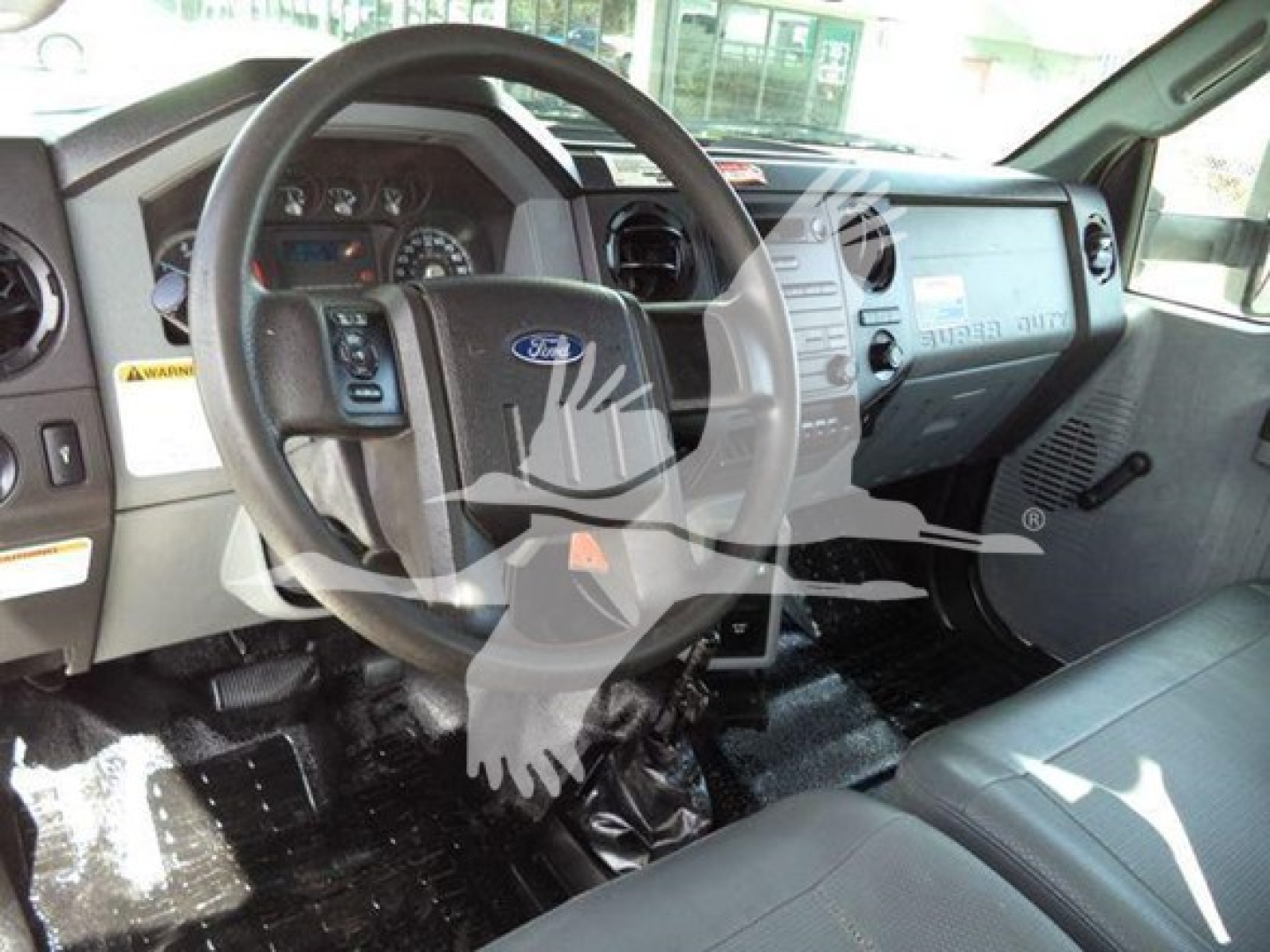 Ford F-750 dashboard and driver’s seat area with steering wheel, instrument cluster, and center console; visible text on dashboard and panels including Ford emblem.