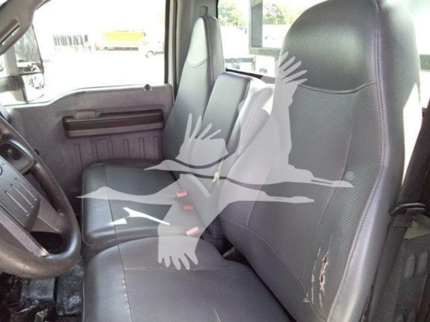 Interior front seats of a Ford F-750 bucket truck showing driver and passenger seats, steering wheel, and door panel.
