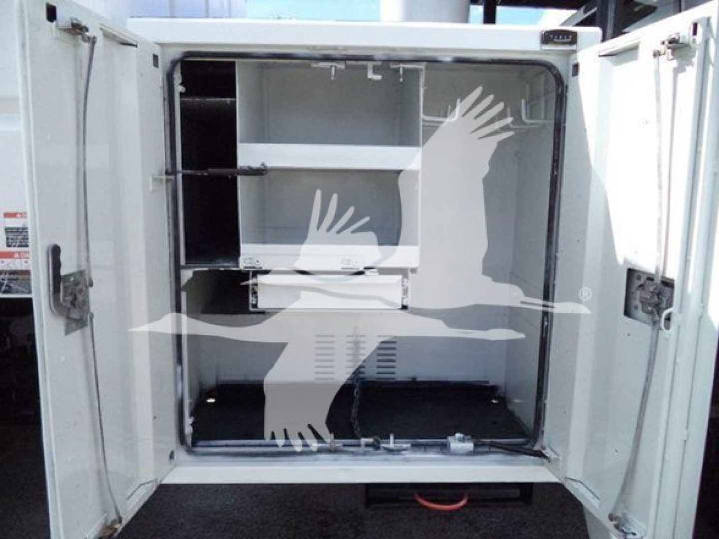 Truck storage compartment with shelves inside, doors open, white interior, utility vehicle.