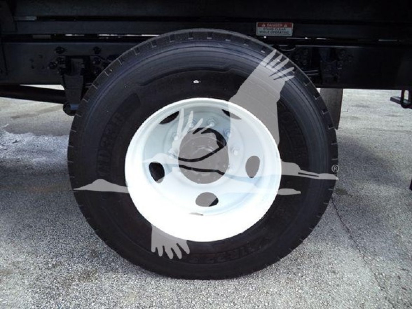 Ford F-750 bucket truck wheel showing white steel wheel and black tire.