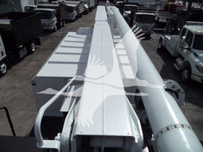 Truck boom lift equipment with long white telescoping arm and hydraulic cylinders viewed from above.