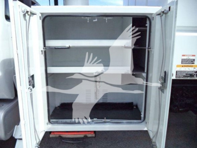 Ford F750 bucket truck rear cargo area with empty storage compartments and doors open.