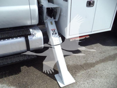 Truck side with a drop-down step/air step extended from cab door; visible text on the metal step and side panel shows safety markings and a small logo.