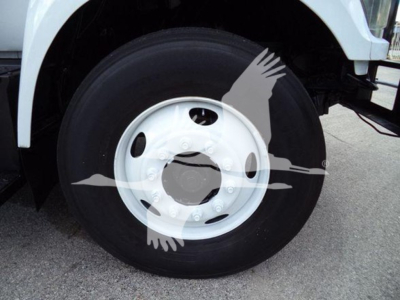 Truck wheel and tire close-up showing front axle and white steel rim with hub and lug nuts.