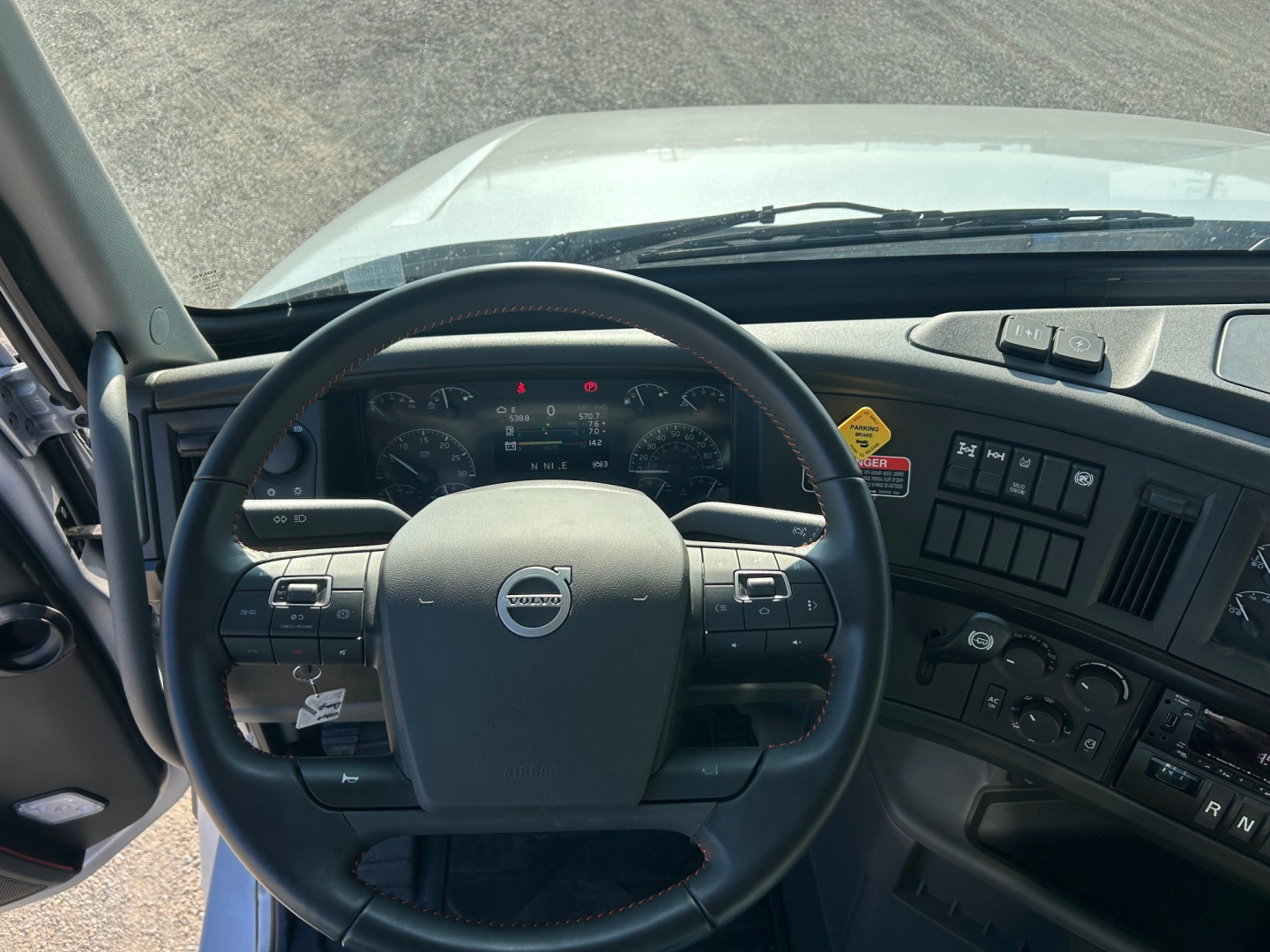 Volvo VHD84F300 truck cab interior showing steering wheel and dashboard with controls and gauges.
