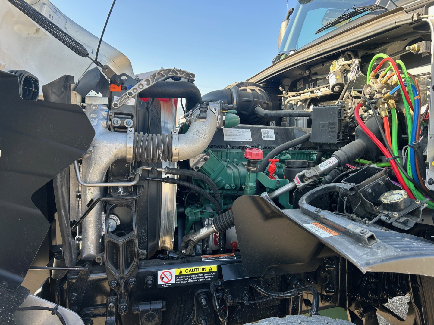 Volvo VHD84F300 engine bay showing engine block, hoses, wiring harness, coolant reservoir, and exposed components.