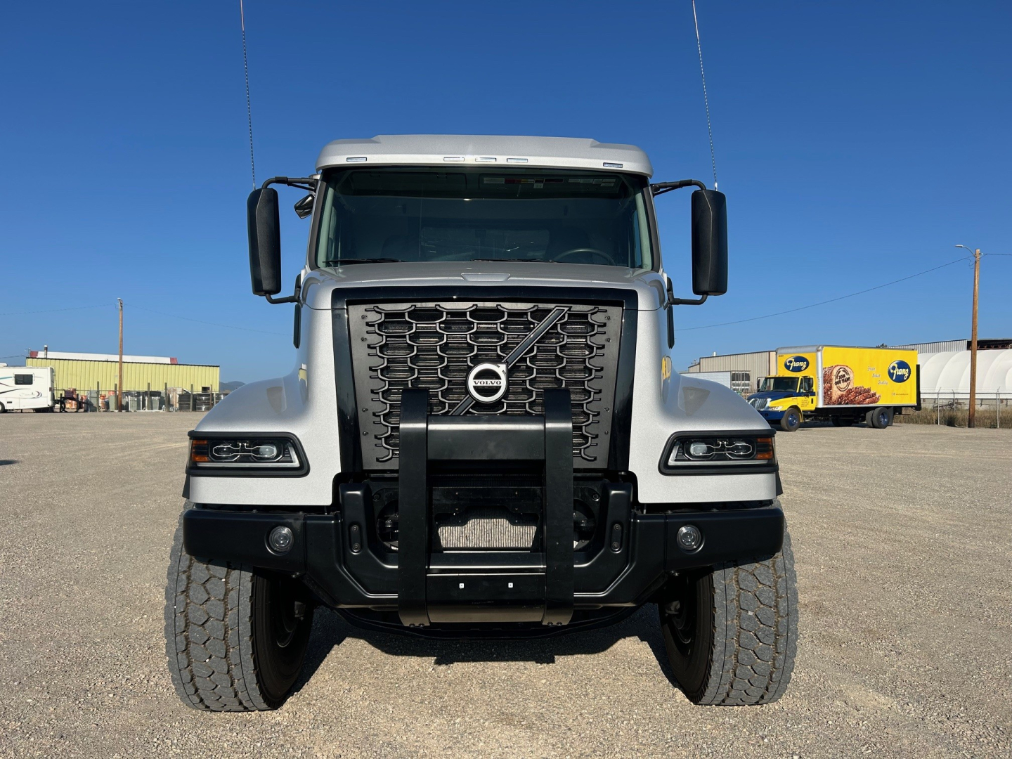 Volvo VHD84F300 dump truck front view showing grille, bumper guard, headlights, Volvo emblem, and large tires.