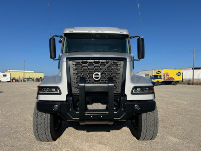 Volvo VHD84F300 dump truck front view showing grille, bumper guard, headlights, Volvo emblem, and large tires.