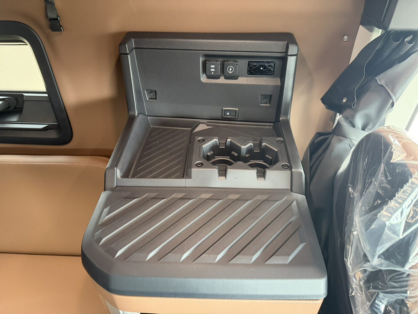 Mack PR64T76H truck interior center console with cup holders and storage, USB-C/12V ports, and power outlet panel.