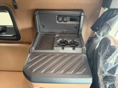 Mack PR64T76H truck interior center console with cup holders and storage, USB-C/12V ports, and power outlet panel.