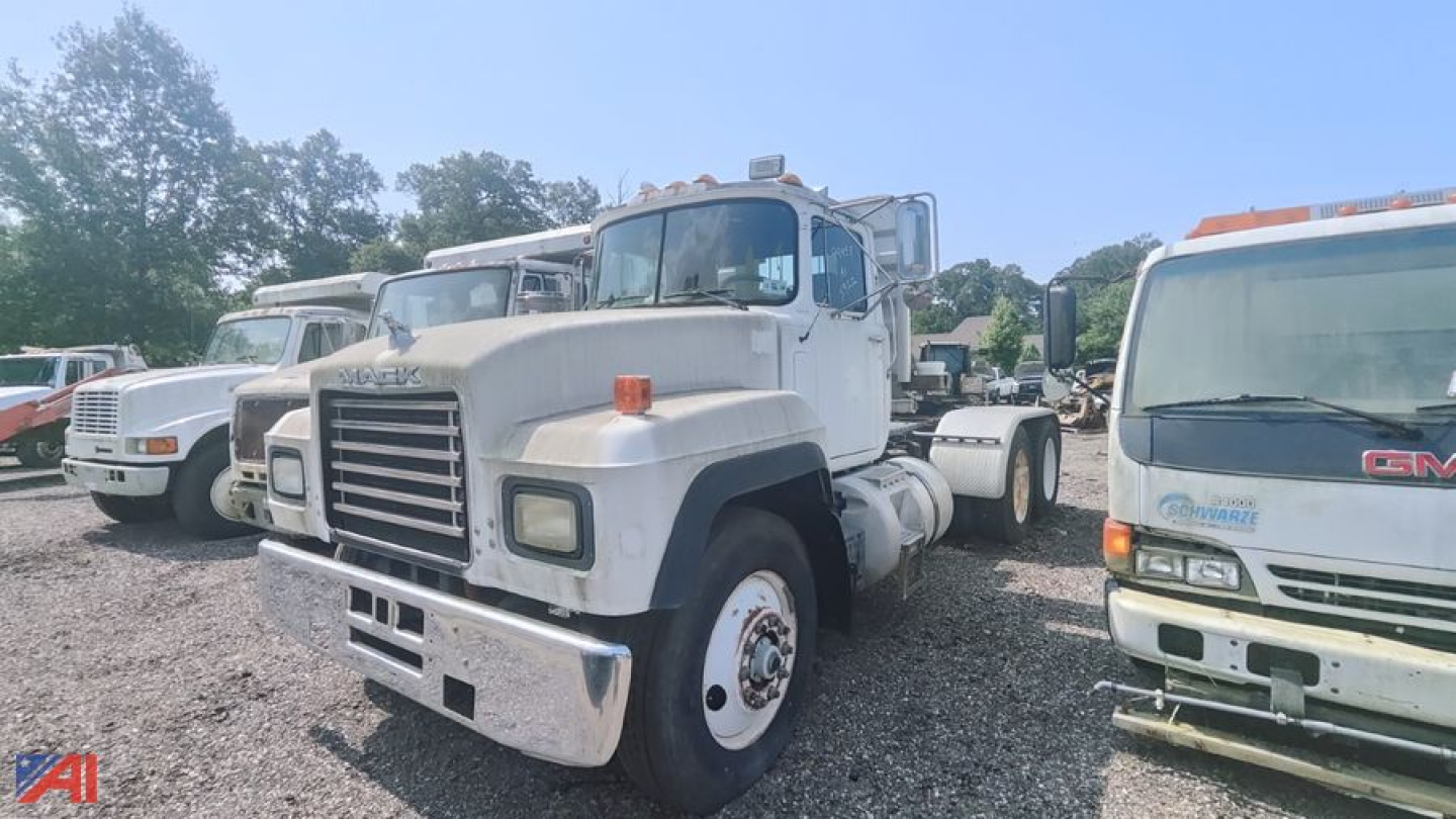 Truck cab front view of a white 1998 Mack E7 conventional daycab showing large chrome bumper and grille with orange marker lights.