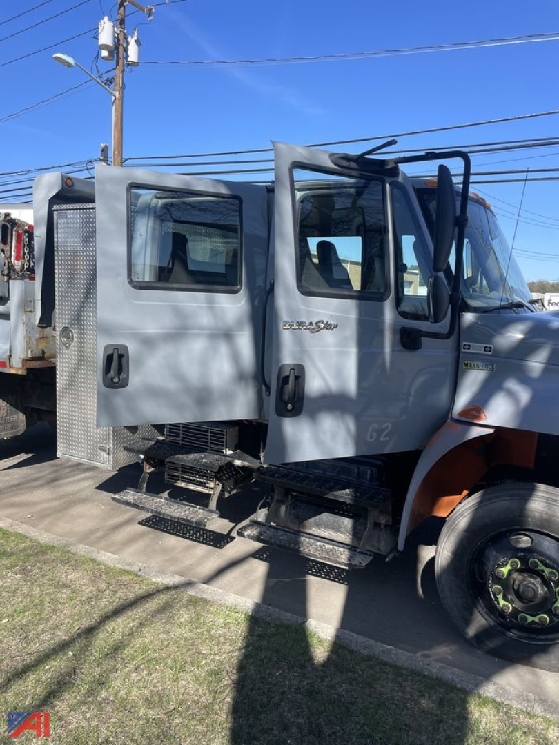 Cabin side view of 2012 International DuraStar 4300 Crew Cab Dump Truck with grey exterior and step ladder, visible side mirrors and doors.