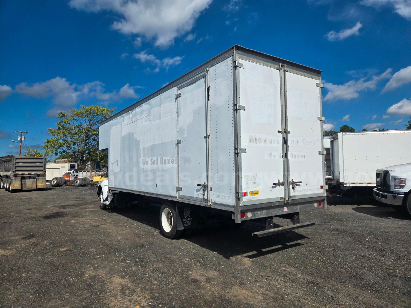 Kenworth box truck trailer in a used stock lot with a white box, rear doors, and single rear axle.